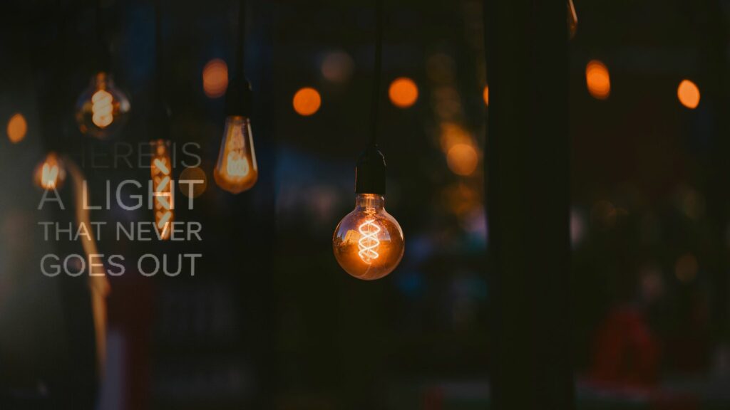 Kuvassa on lamppuja pimeydessä ja teksti "there is a light that never goes out"