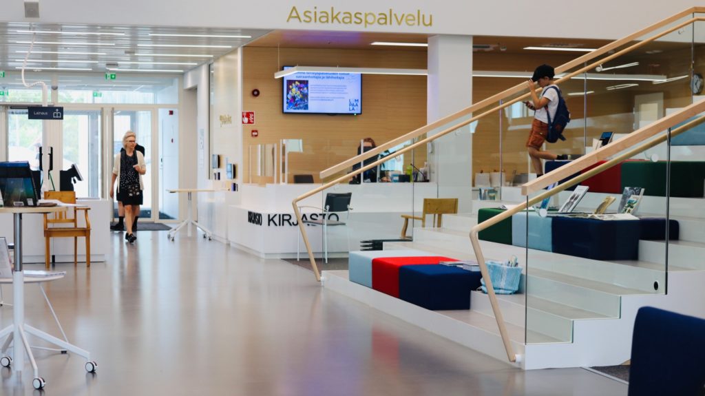 Lempäälän kirjaston pääaulan portaita ja kirjaston asiakaspalvelu.
