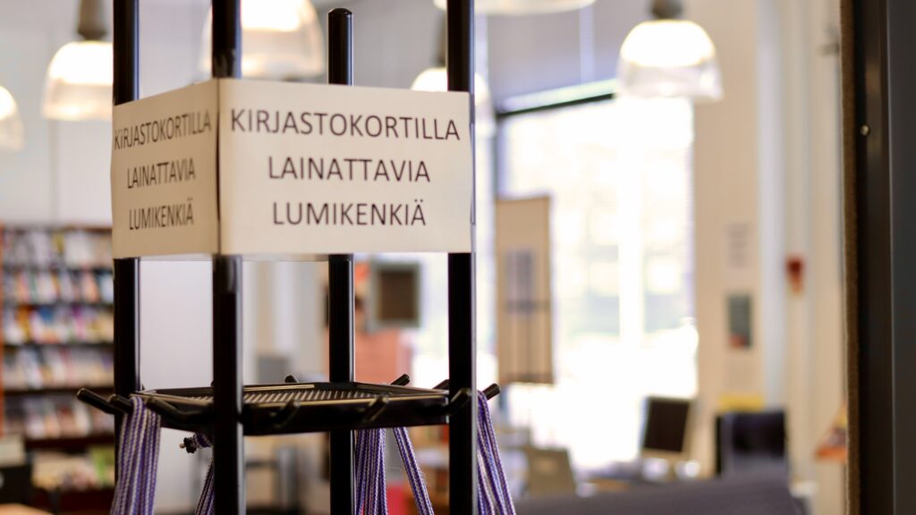 Kirjastokortilla lainattavia lumikenkiä -teksti Joutsan kirjastosalissa.