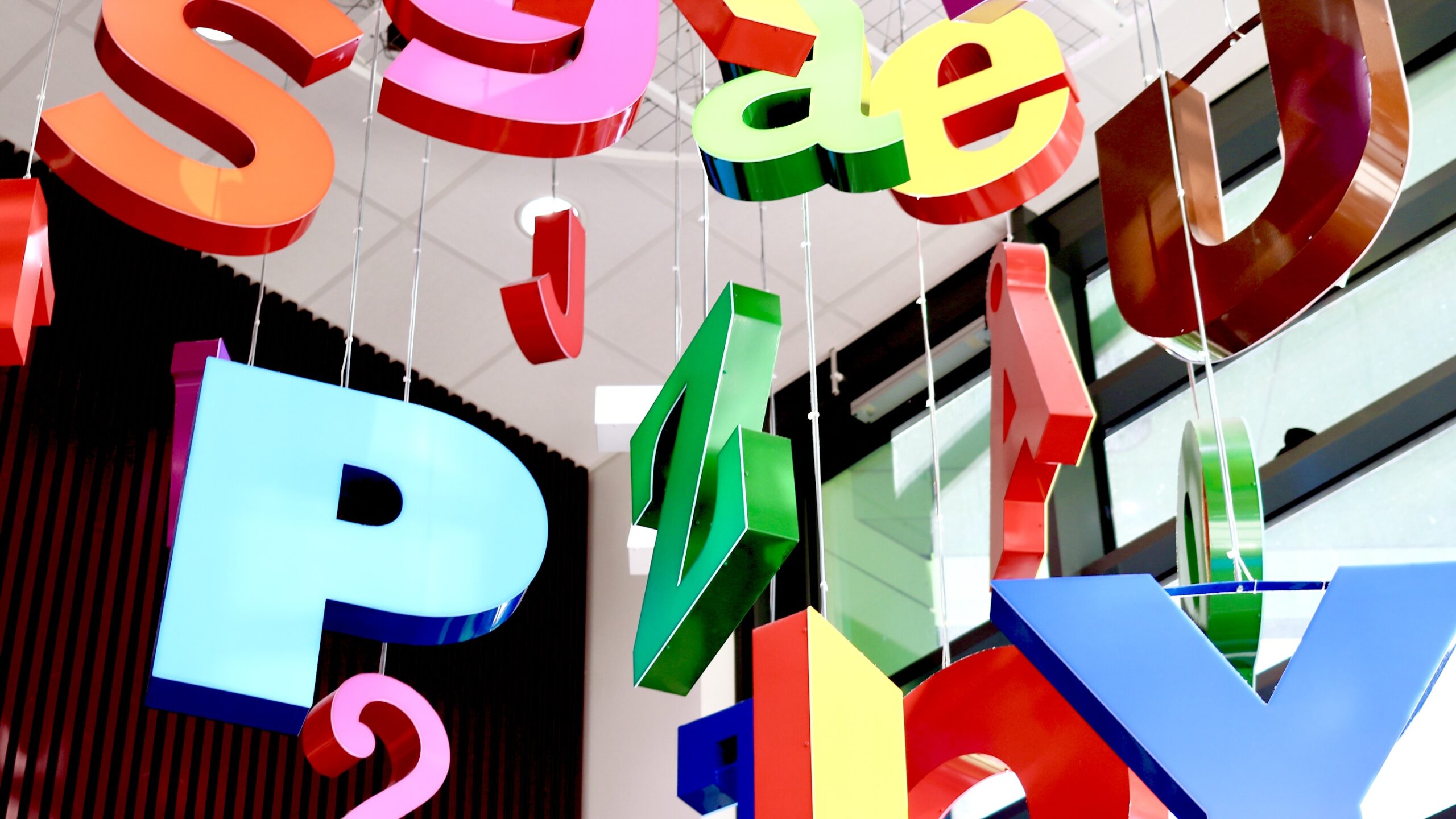 Erivärisiä kirjaimia katossa Pirkkalan Nuolialan kirjastossa.