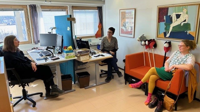 Kolme ihmistä keskustelemassa Jyväskylän pääkirjaston työhuoneessa.