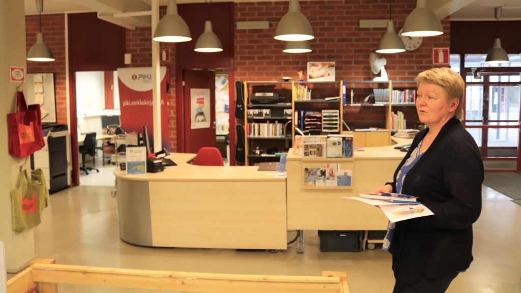 Kuvassa Ruoveden kirjaston asiakaspalvelupiste ja johtaja Outi Ylinen PIKI-kirjastokiertueen ajalta vuonna 2018.