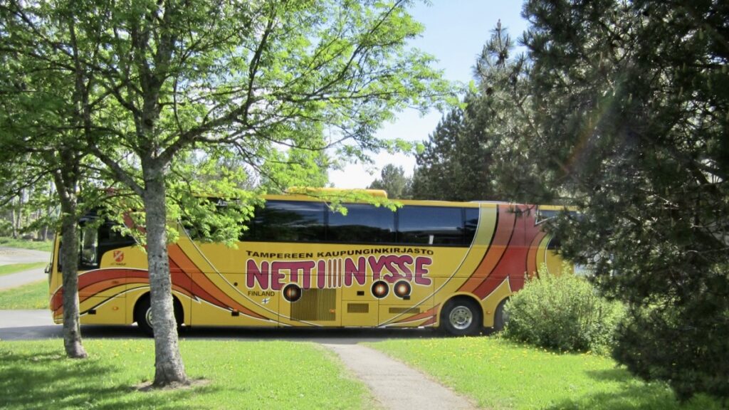 NettiNysse -bussi puiden ja vihreän puiston keskellä.