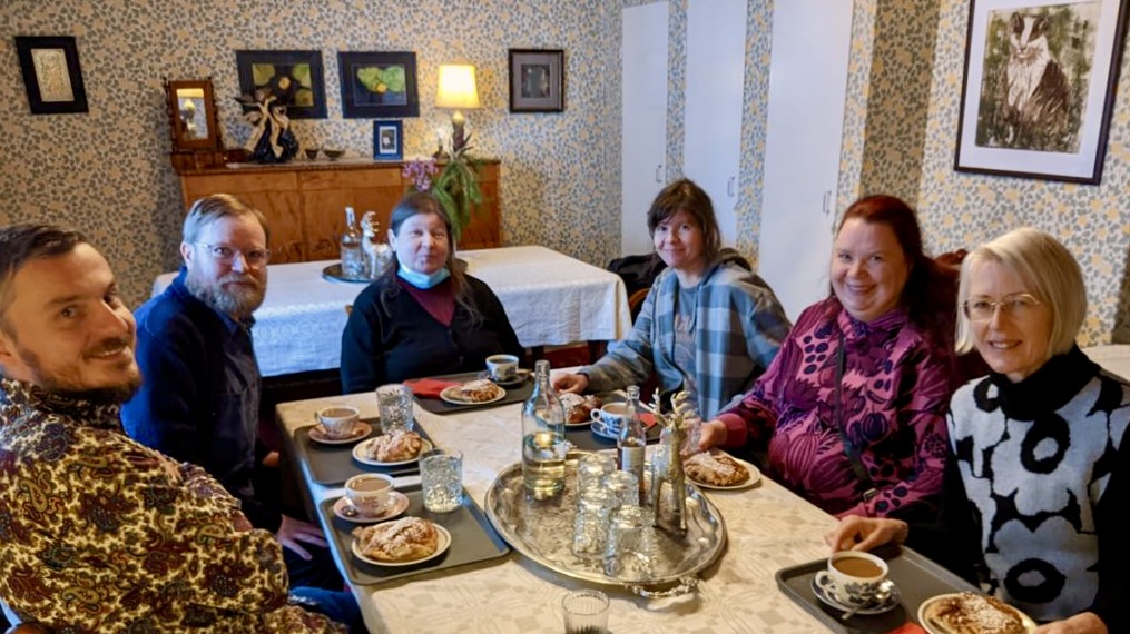 Yhteiskuva ihmisistä pöydän ääressä.