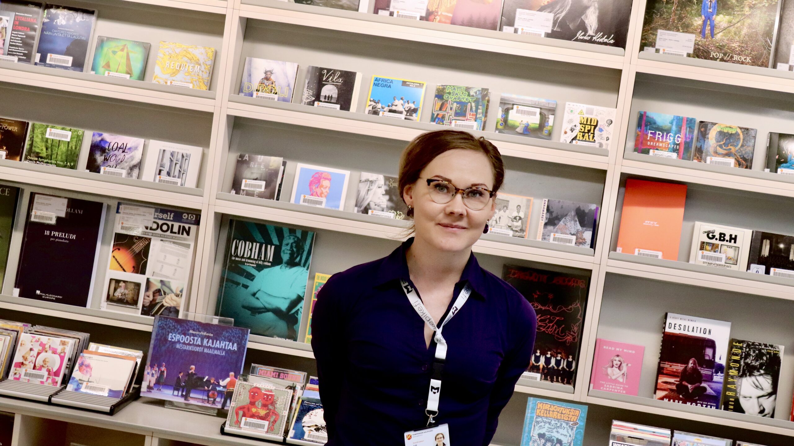 Koordinaattori Juli levynkansien edustalla pääkirjasto Metsossa.