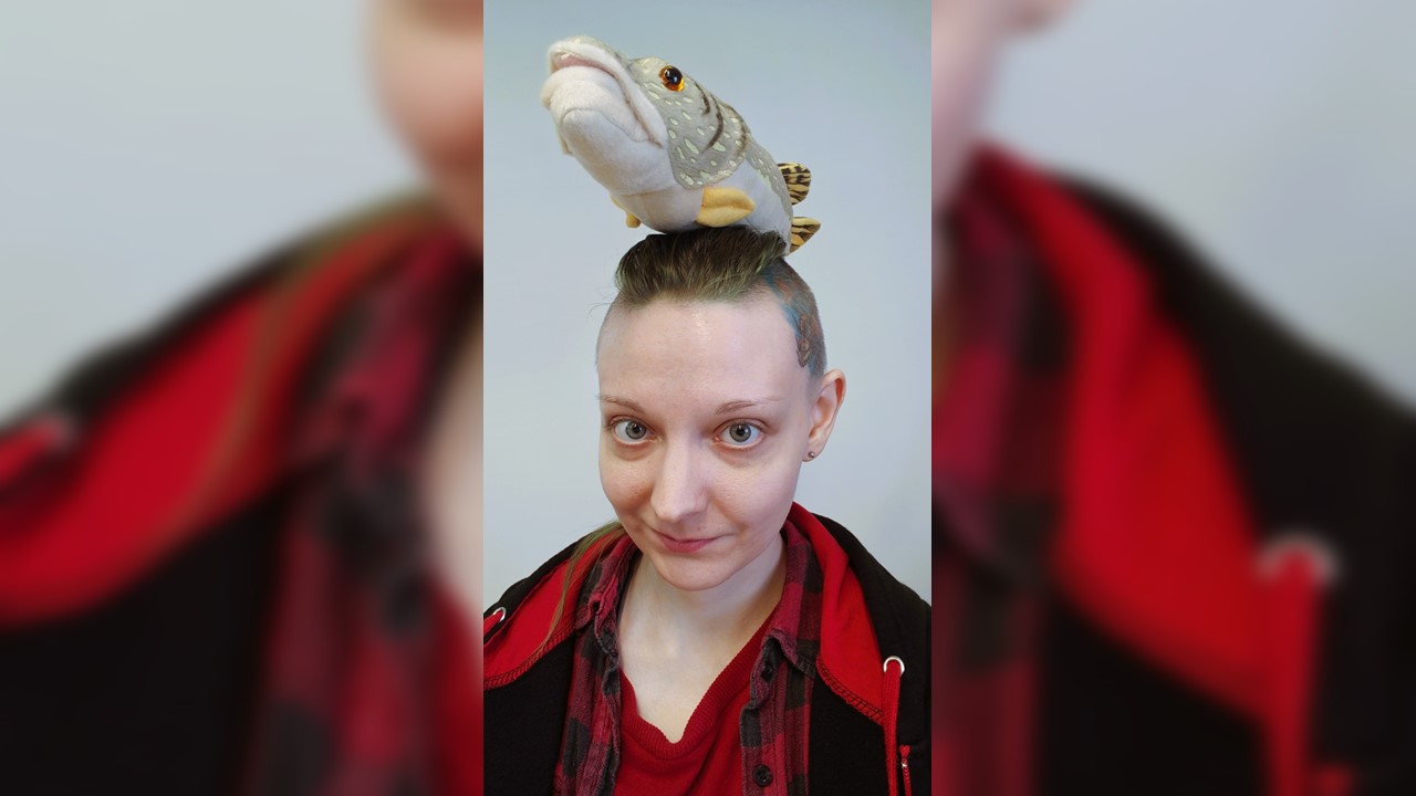 Syksy Siitari lähikuvassa. Pään päällä Pike-pehmohauki.