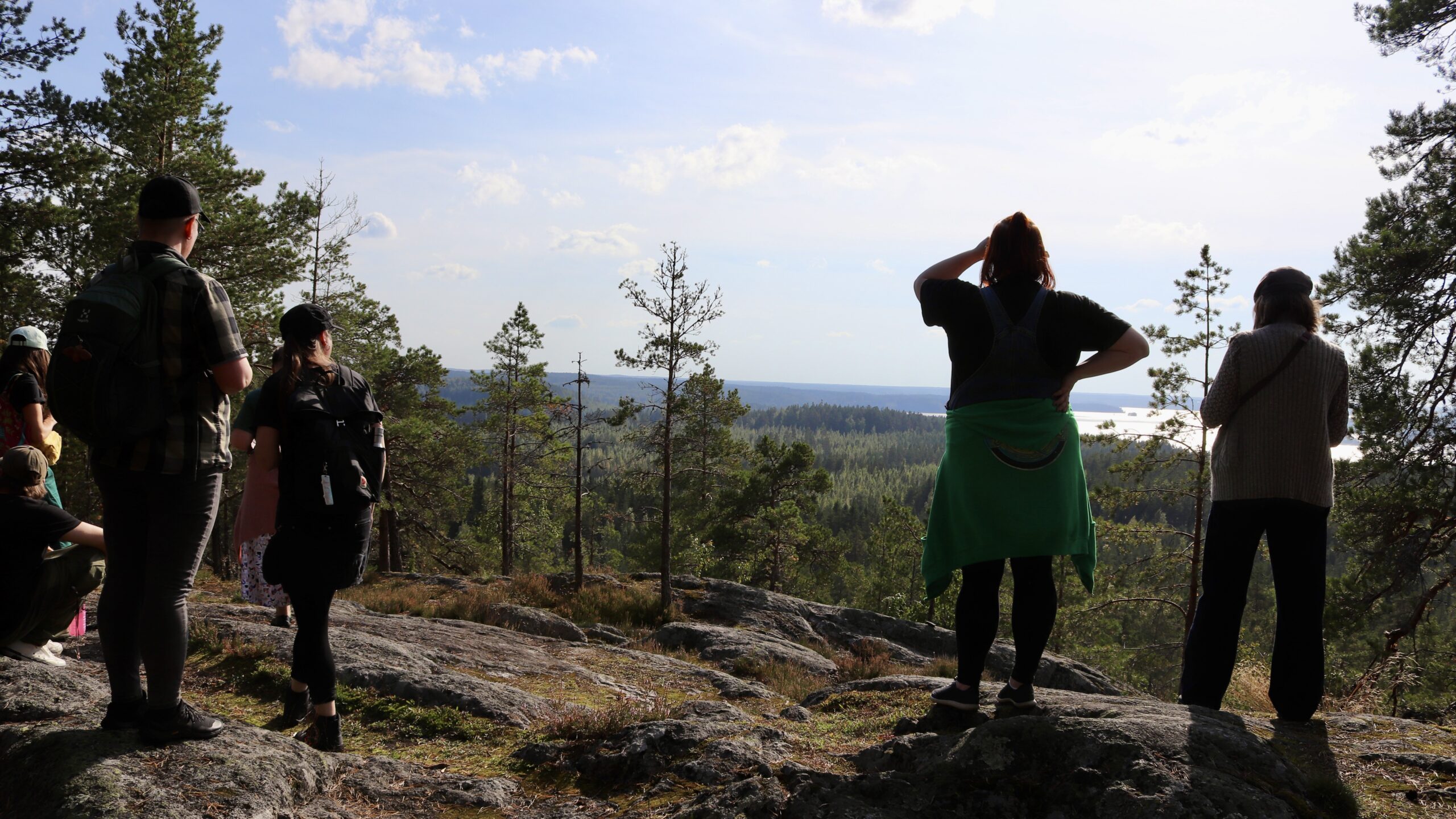 Henkilöitä järven ylle avautuvalla näköalapaikalla seisomassa selin kameraan Sastamalan Pirunvuorella.