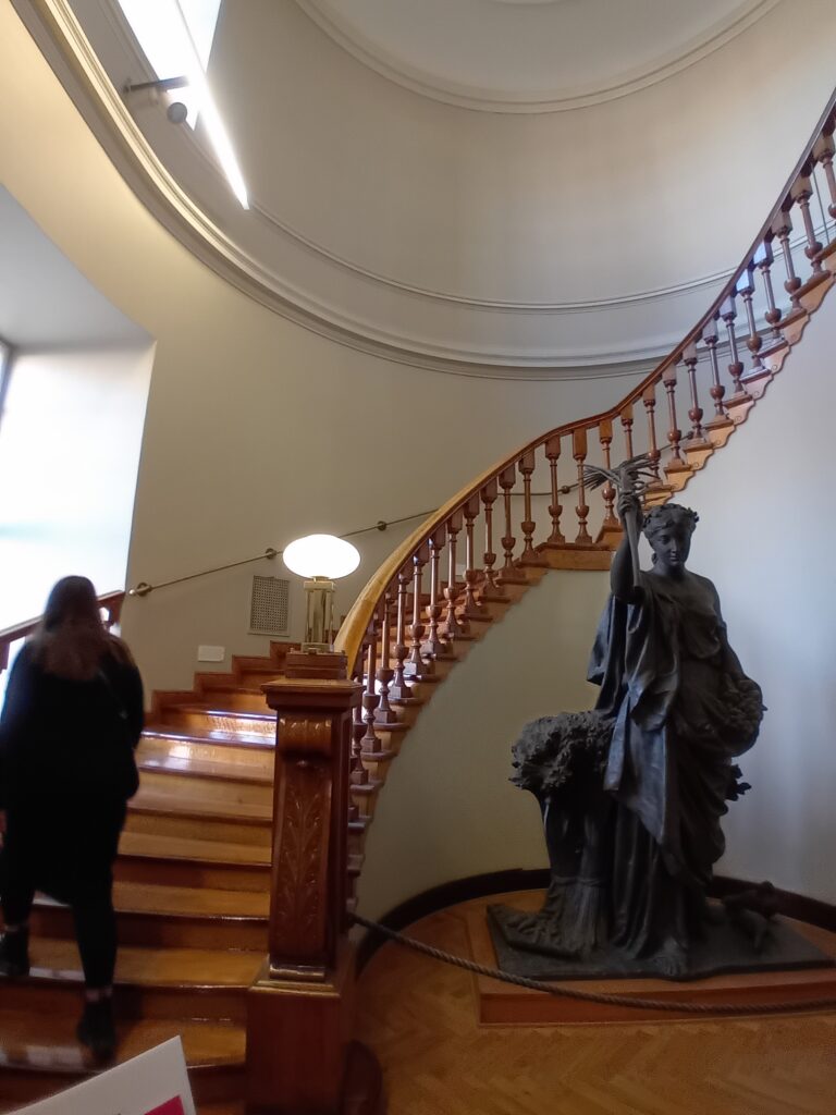 Tummat, puiset, ylöspäin kiemurtelevat kierreportaat Turun pääkirjaston vanhan puolen aulassa.