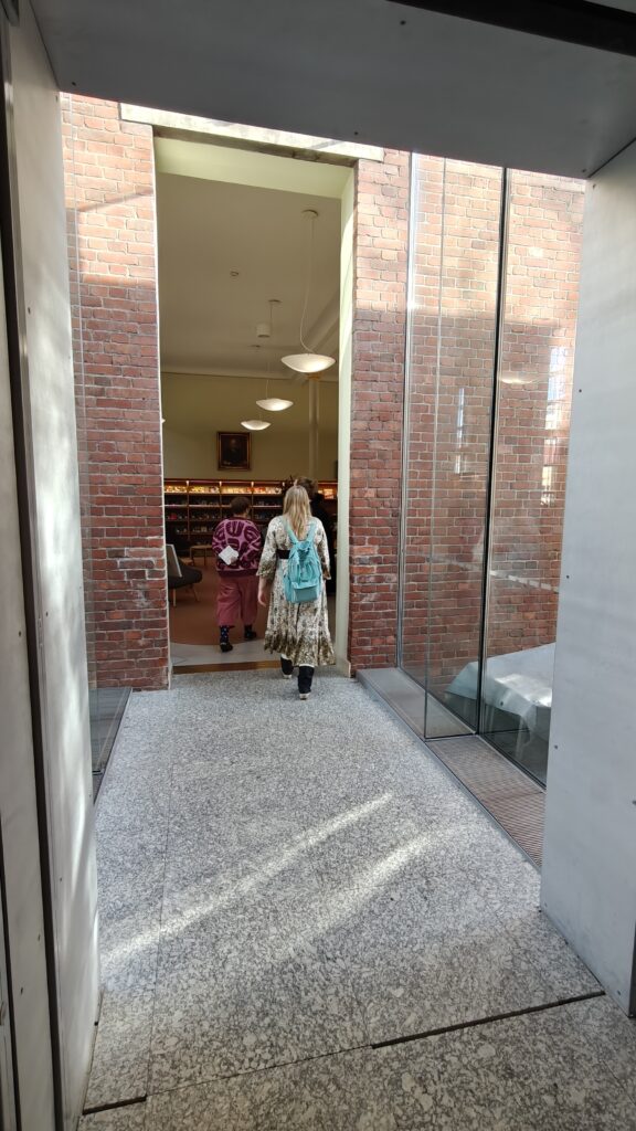 Valoisa lasiseinäinen yhdyskäytävä Turun pääkirjastossa.