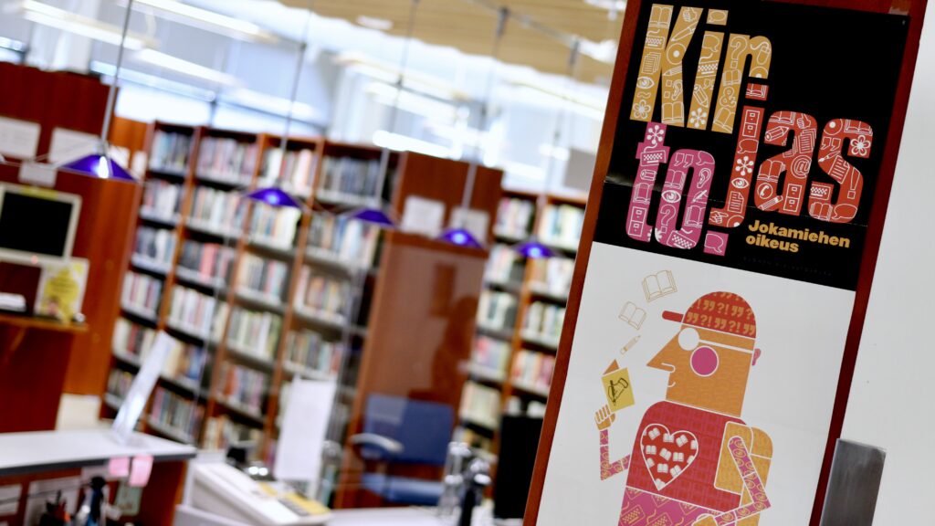 "Kirjasto on jokamiehen oikeus" -juliste Joutsan pääkirjaston salissa.