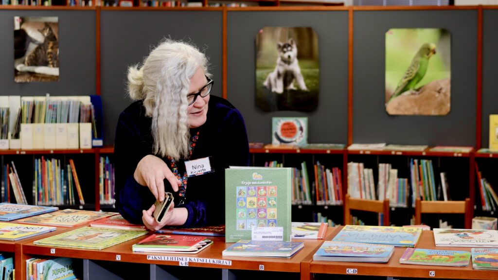 Joutsan kirjasto- ja kulttuuritoimen päällikkö Nina Kuikka nojaa lastenosaston matalaan kirjahyllyyn.