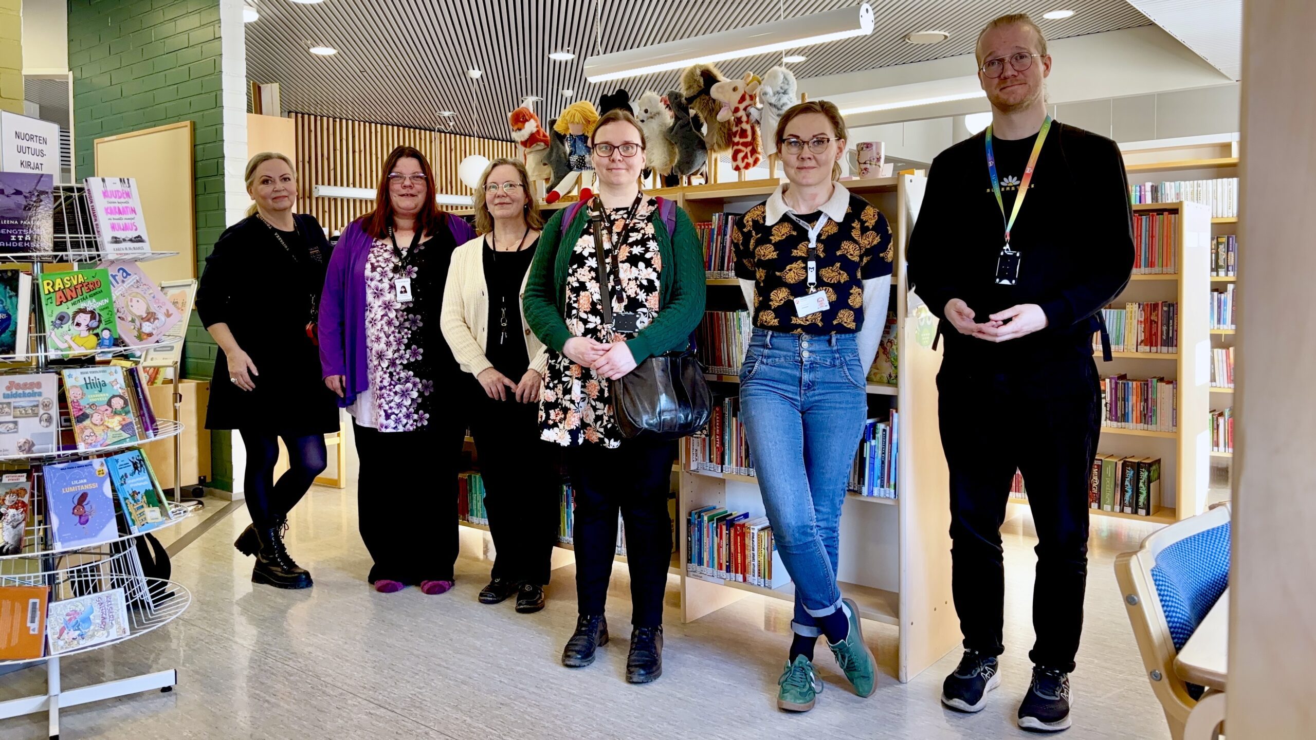 Toivakan kirjaston koko henkilökunta yhteiskuvassa kirjastosalissa.