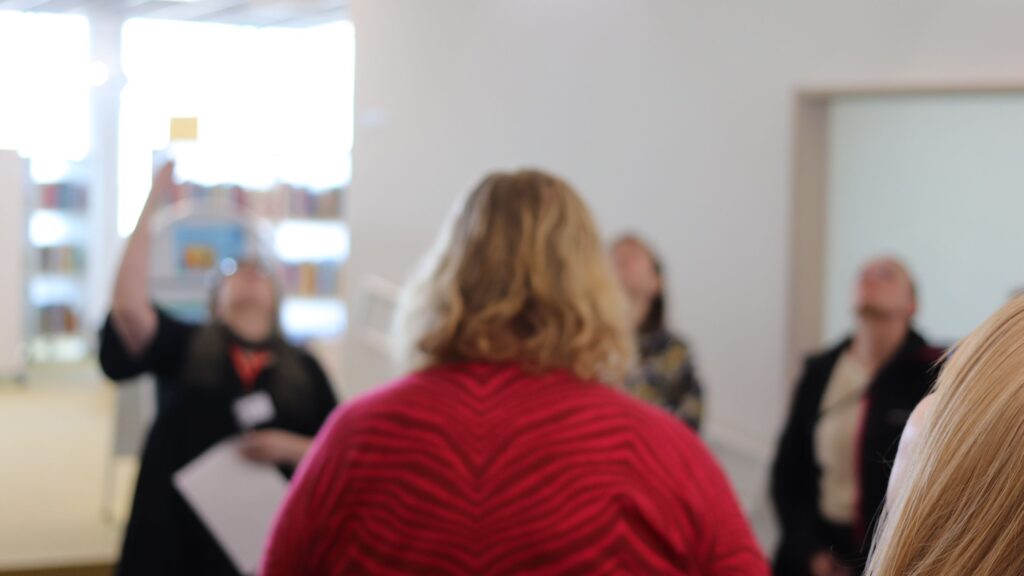 Oppimisvierailun osallistujat ihastelevat Virran pääaulan "Tippapeli"-taideteosta.