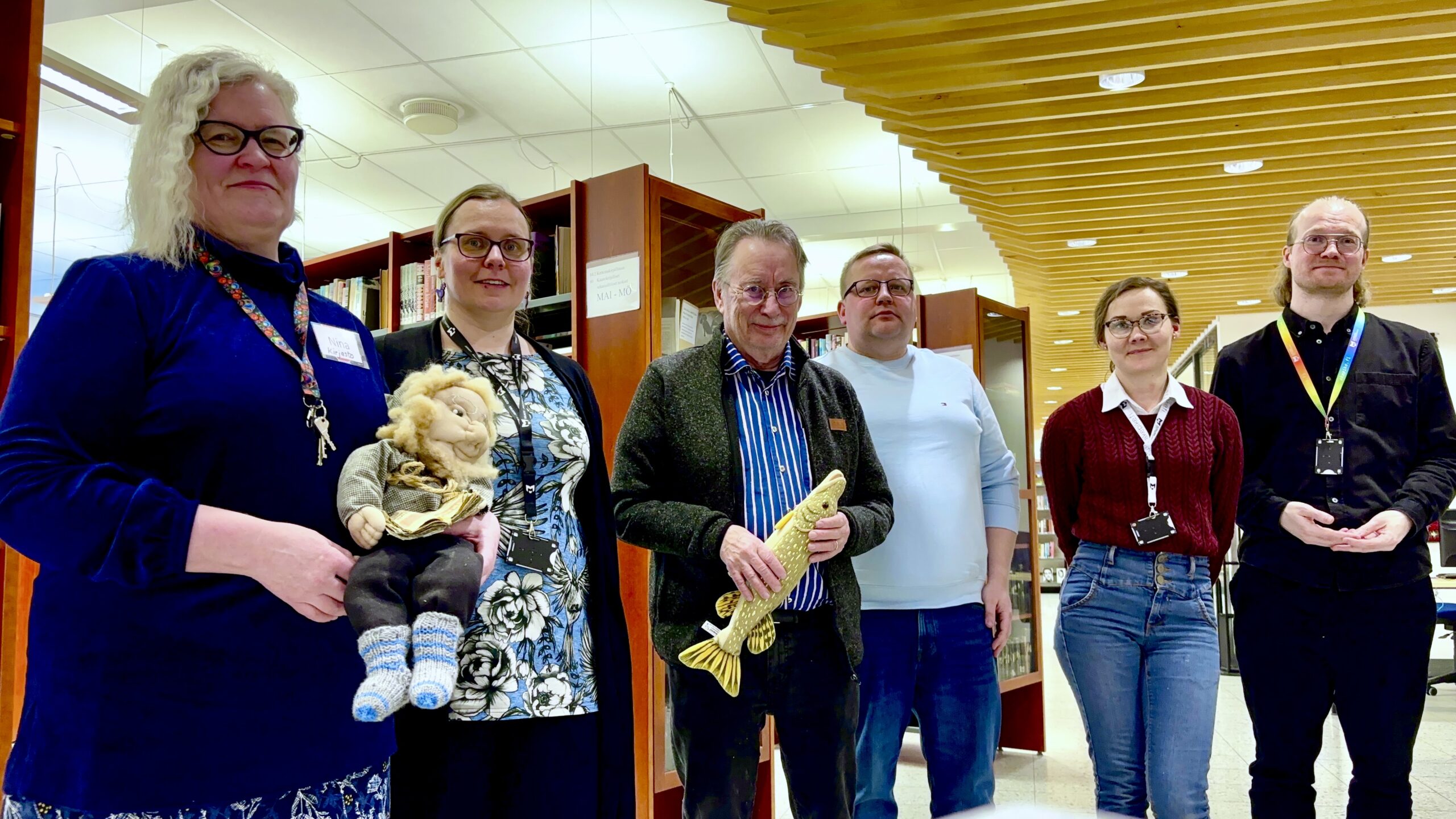 Joutsan kirjaston henkilökuntaa ja kunnanvaltuuston jäseniä yhteiskuvassa kirjastosalissa.