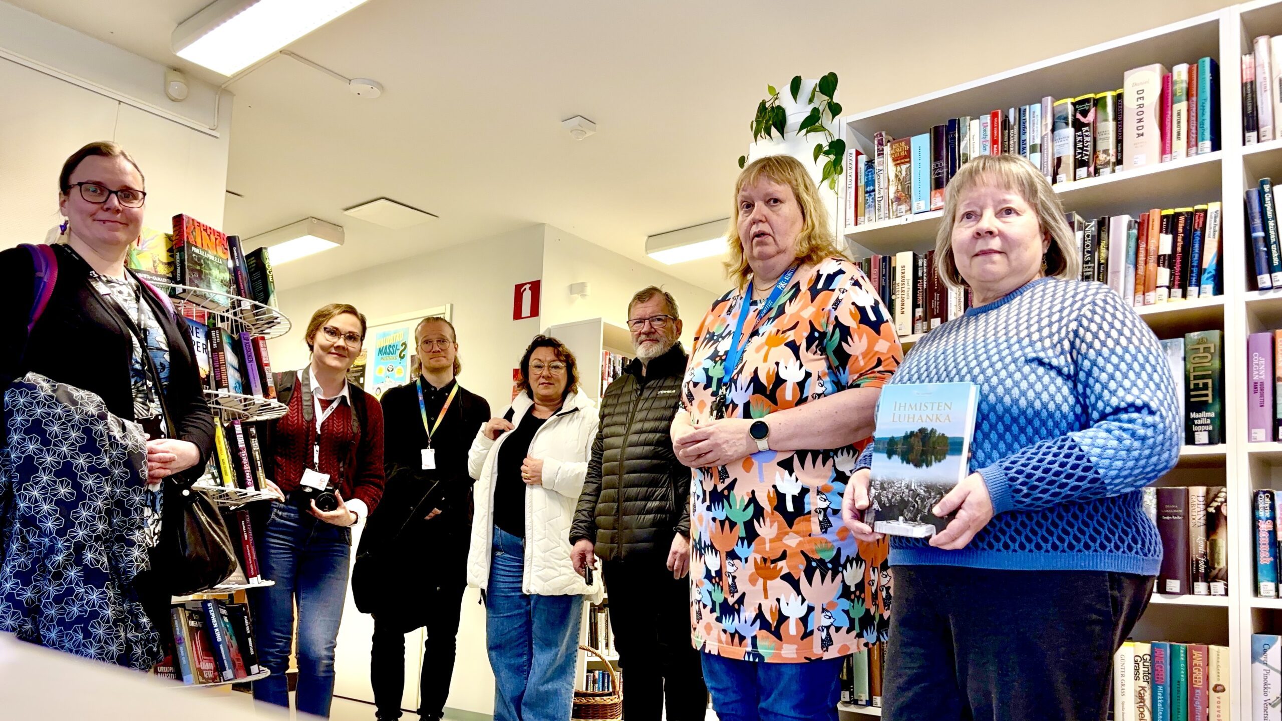Luhangan kirjaston ja kunnan henkilökuntaa sekä päättäjiä yhteiskuvassa kirjastosalissa.