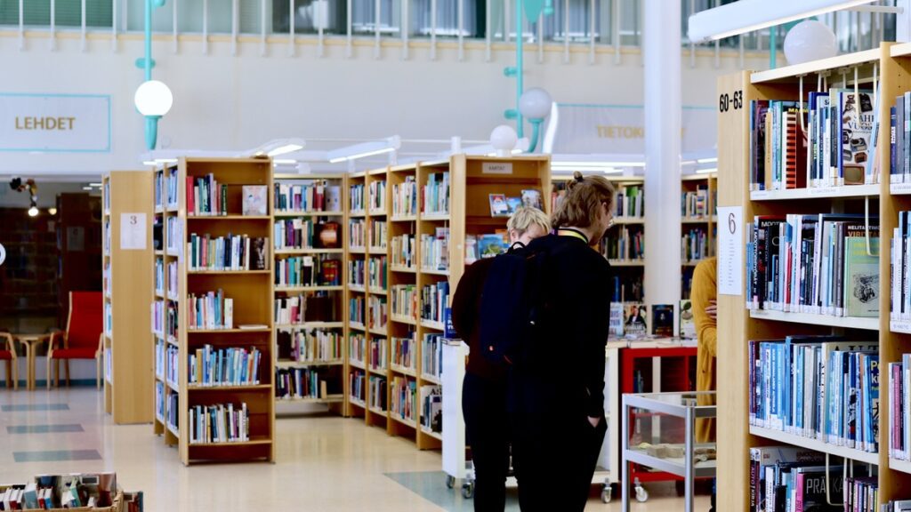 AKE-koordinaattori ja Oriveden kirjaston henkilöstö keskustelemassa valoisassa kirjastosalissa.