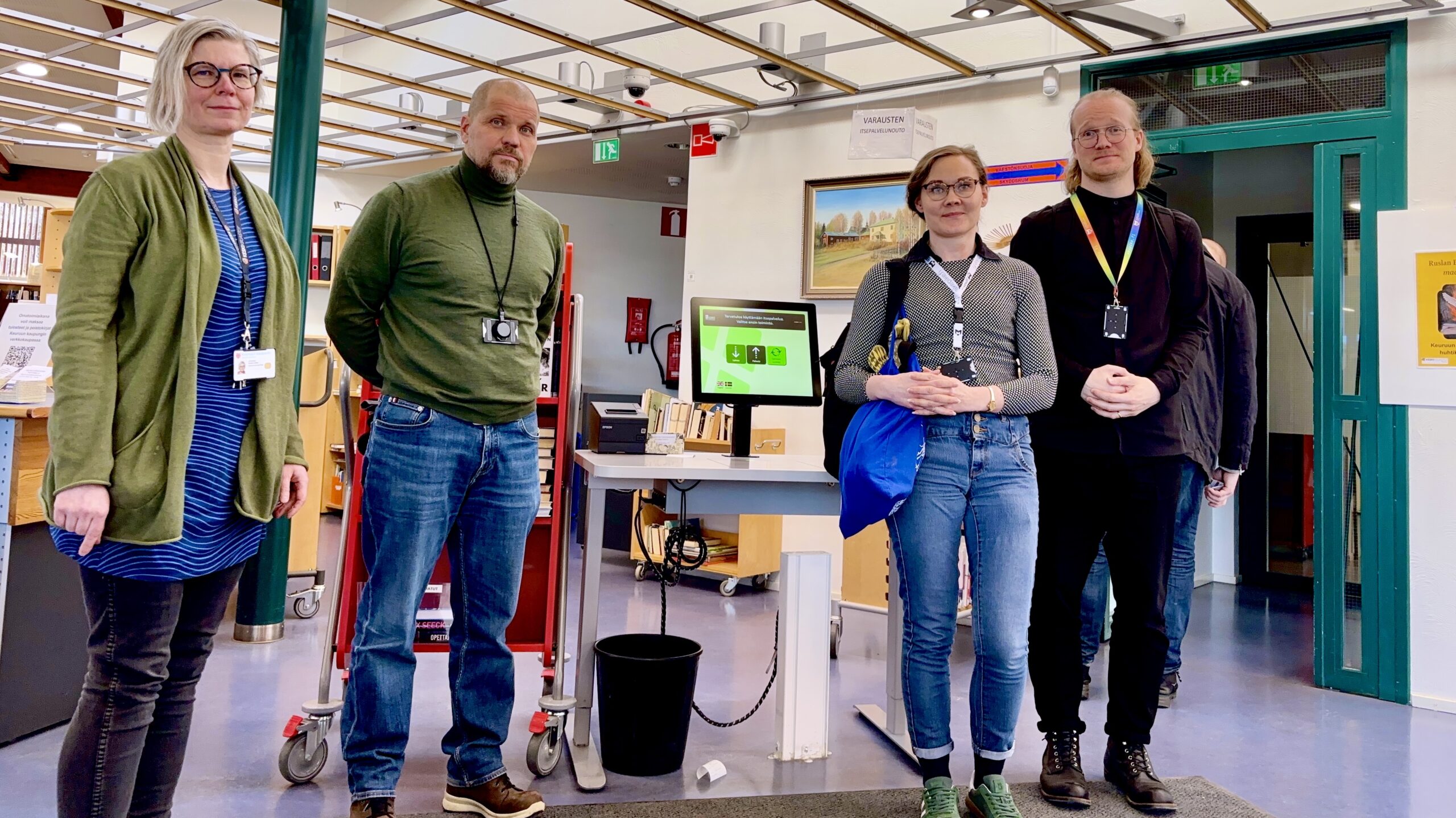 Keuruun kirjastokeskustelijat yhteiskuvassa lainausautomaatin ympärillä.