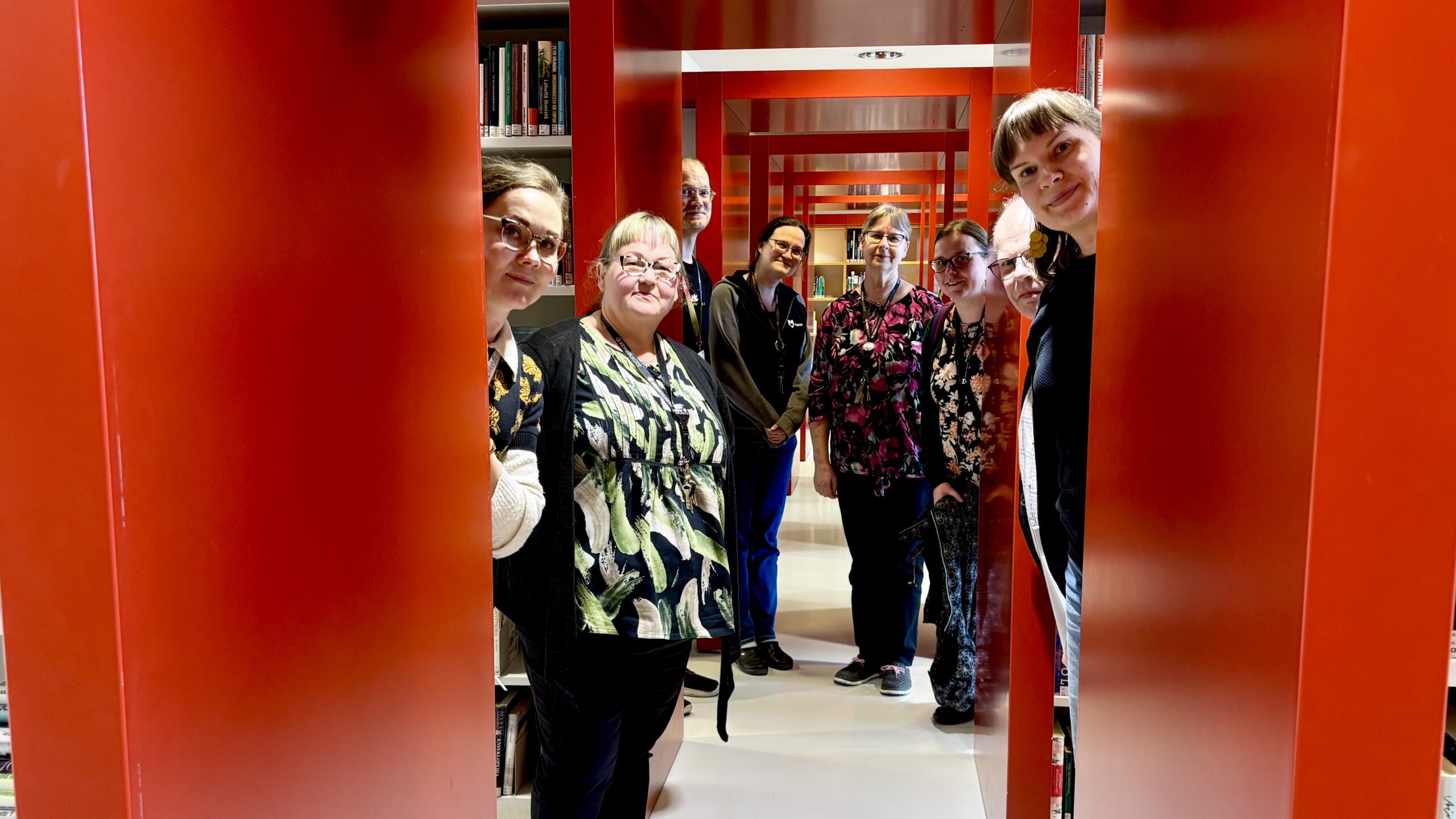 Punaisia hyllyjä ja ihmisiä.