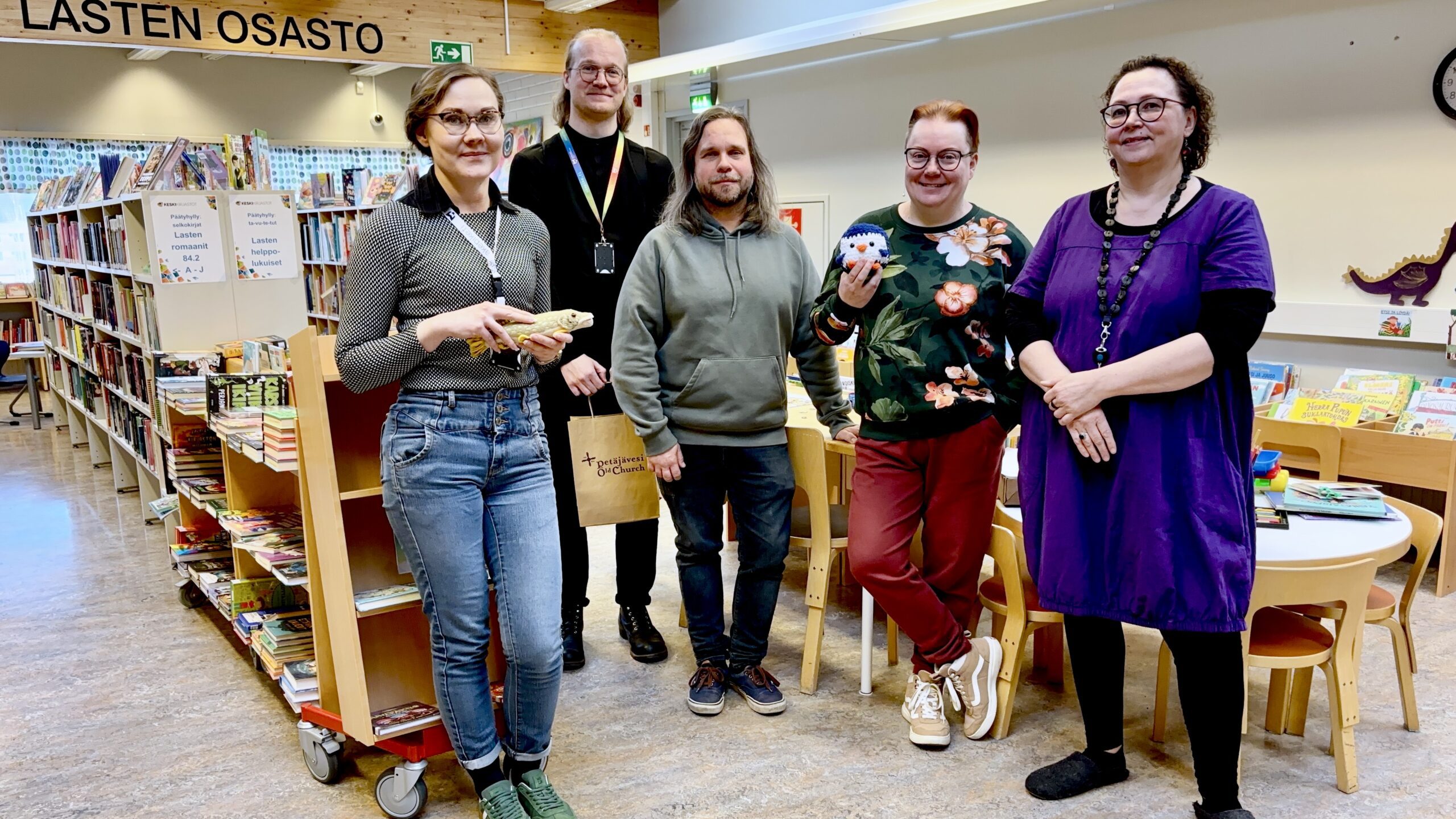 Petäjäveden kirjaston henkilökunta ja AKE-koordinaattorit kuvattuna Petäjäveden kirjaston lastenosastolla.
